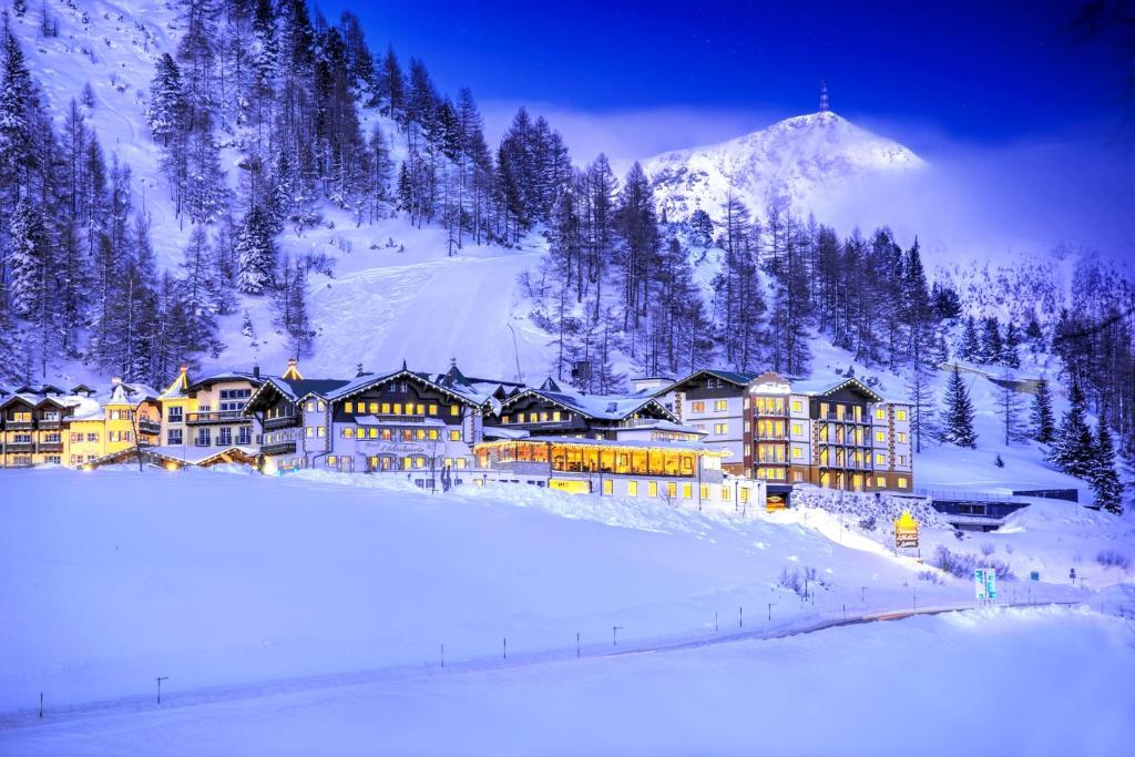 un complexe dans la neige avec une montagne dans l'établissement Appartement & Suiten Hotel Glöcknerin, à Obertauern