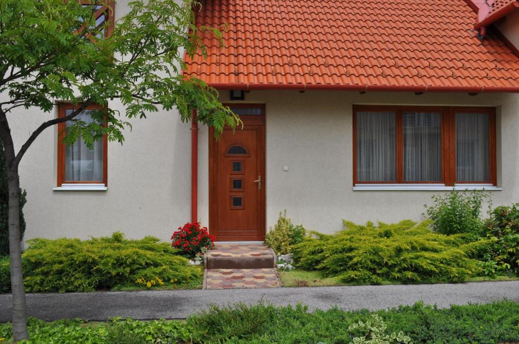 een wit huis met een oranje dak bij Betérő Apartman Veszprém in Veszprém