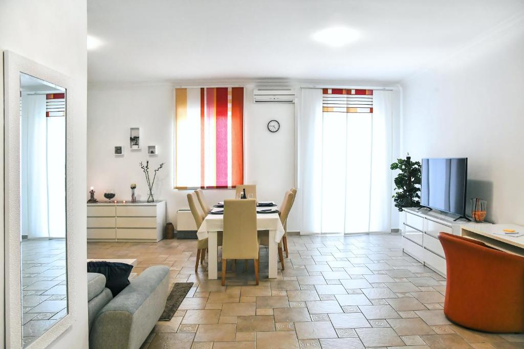 a living room with a table and a dining room at Apartman LUI in Rijeka