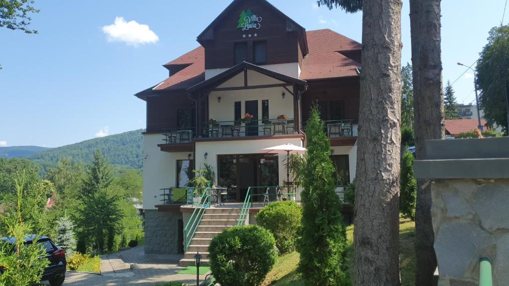 a large house with a balcony and stairs to it at Vila Laura 1 in Sovata