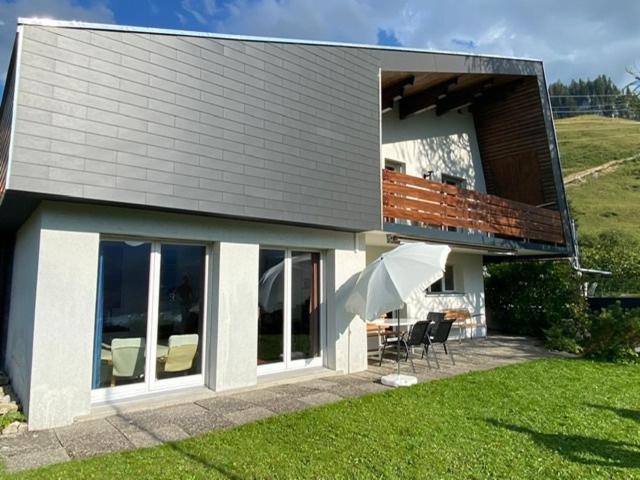 a house with a patio and an umbrella at Ferienhaus Relax in Schwarzsee