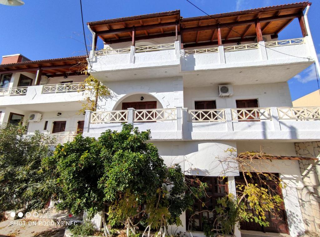 a white building with a balcony on top of it at Keramos in Zaros