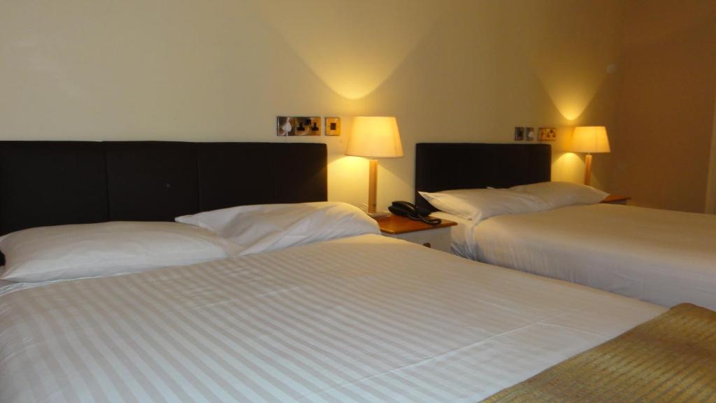 Rúm í herbergi á Hannon's Hotel