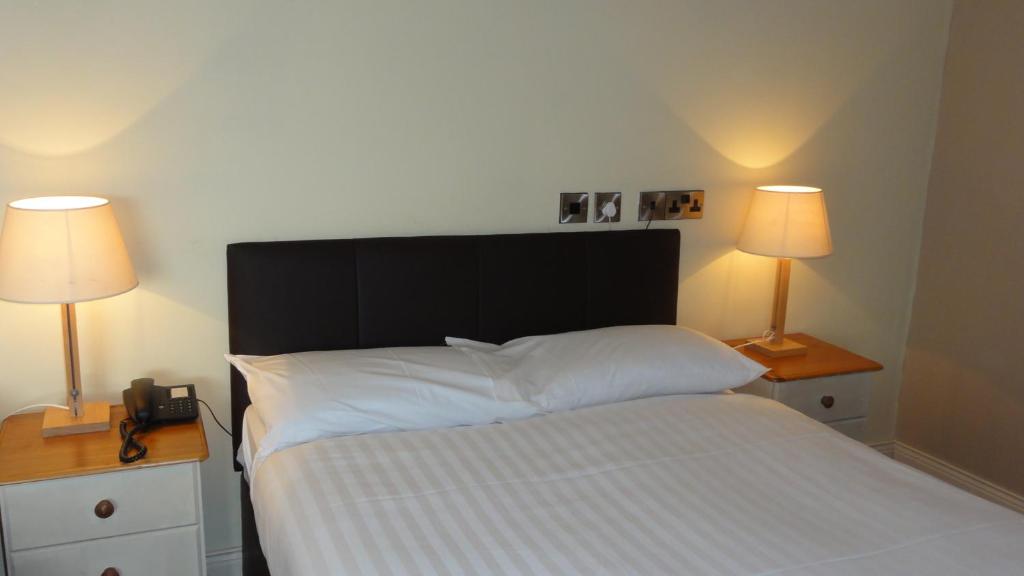 Rúm í herbergi á Hannon's Hotel