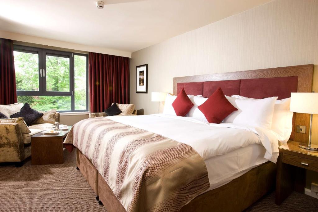 a hotel room with a large bed and a large window at Kingsmills Hotel in Inverness