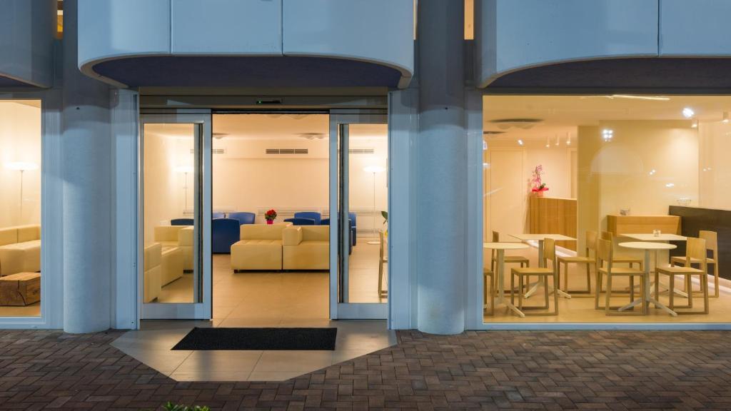 a lobby with tables and chairs in a building at Hotel Mediterraneo in Sottomarina