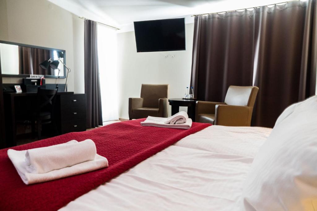 a hotel room with a bed with two towels on it at Comm Hotel Poznań Airport in Poznań