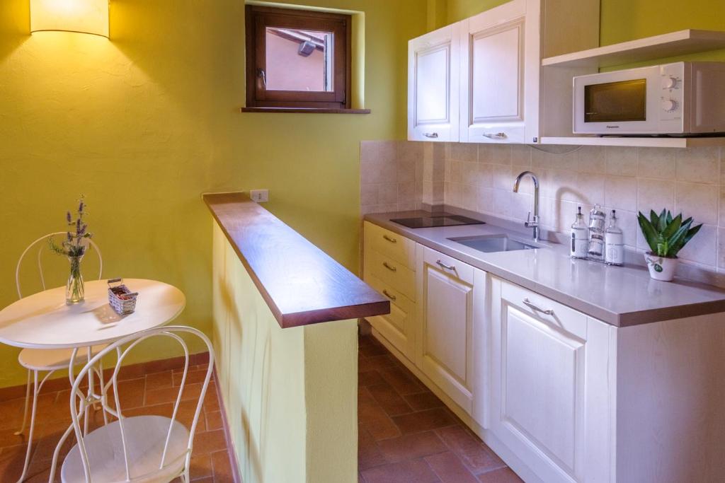 a kitchen with white cabinets and a sink at Agriturismo Le Vigne in Foligno