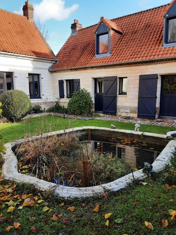 ein Haus mit einem Teich im Hof in der Unterkunft La grange de Fermont in Capelle-Fermont