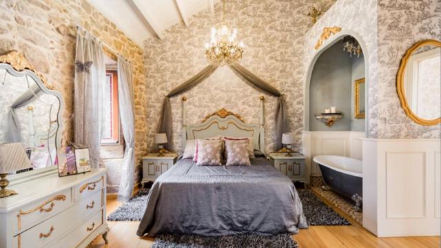 a bedroom with a bed and a tub in a room at Casa de Carmen Bañera chimenea de leña y terraza in Corcubión