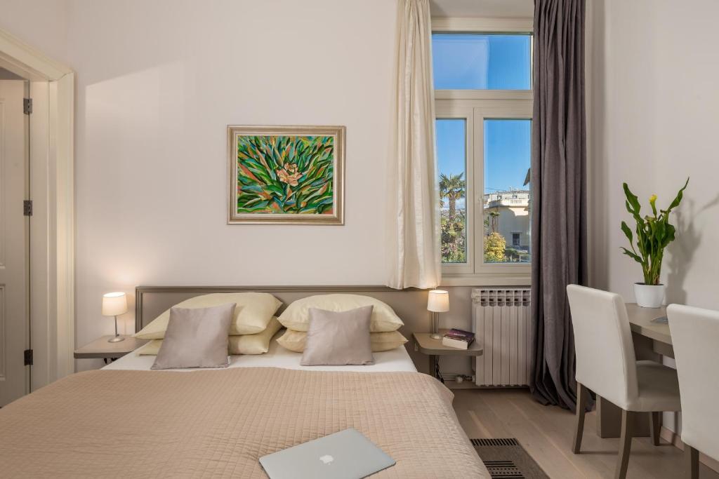 a bedroom with a bed and a desk and a window at Villa Sokol Apartments Opatija center in Opatija