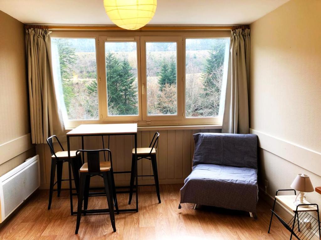 ル・リオランにあるLa Randonnée Résidence Le Bec de L'Aigleのテーブルと椅子、窓が備わる客室です。