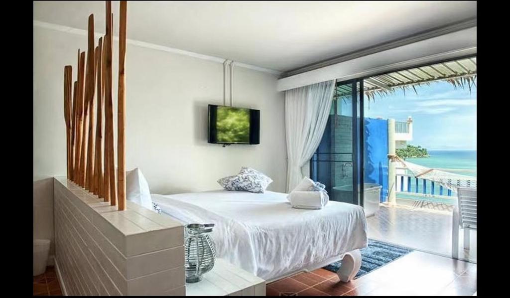 a bedroom with a bed and a view of the ocean at AT SEA Patong in Patong Beach