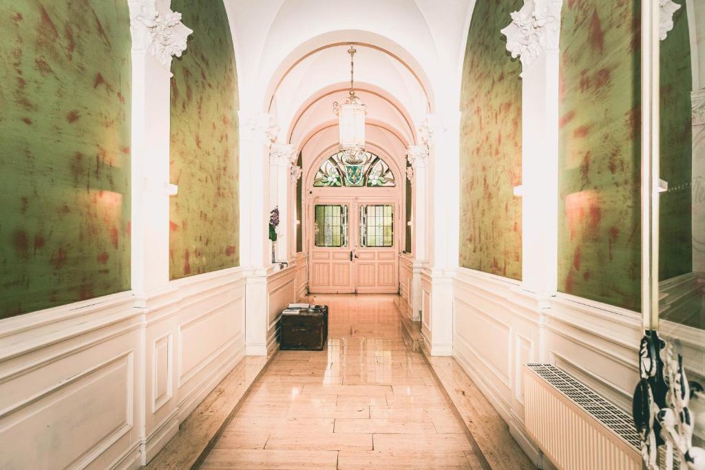 un couloir d'un bâtiment avec une porte rose dans l'établissement Hotel Villa Klemm - Wiesbaden City, à Wiesbaden
