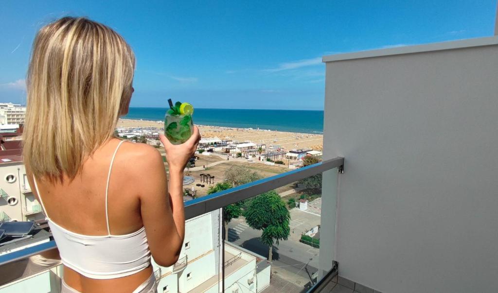 a woman standing on a balcony holding a frog at Eurhotel in Rimini