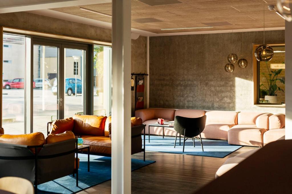 a living room with leather couches and a table at CPH Hotel in Copenhagen