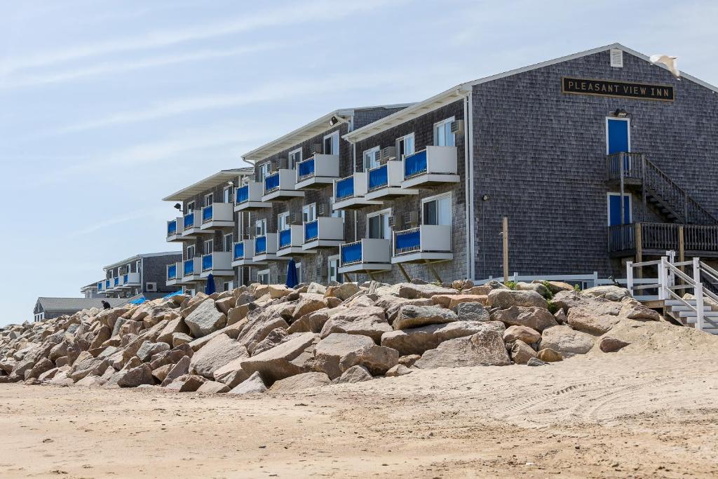 a building on the beach next to some rocks at Pleasant View Inn in Westerly