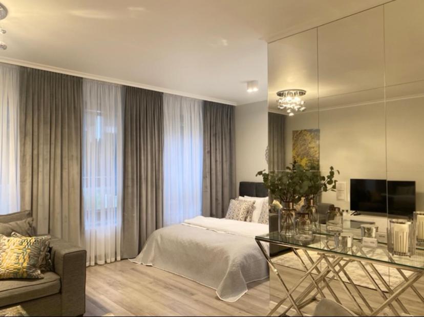 sypialnia z łóżkiem i szklanym stołem w obiekcie Ultra Apartments Kamienica Nova w Szczecinie