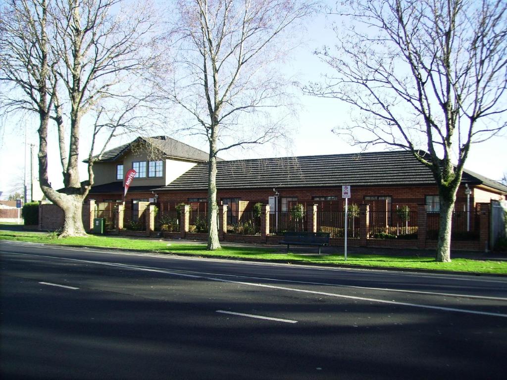 un bâtiment sur le côté d'une rue arborée dans l'établissement Albert Court Motor Lodge, à Hamilton