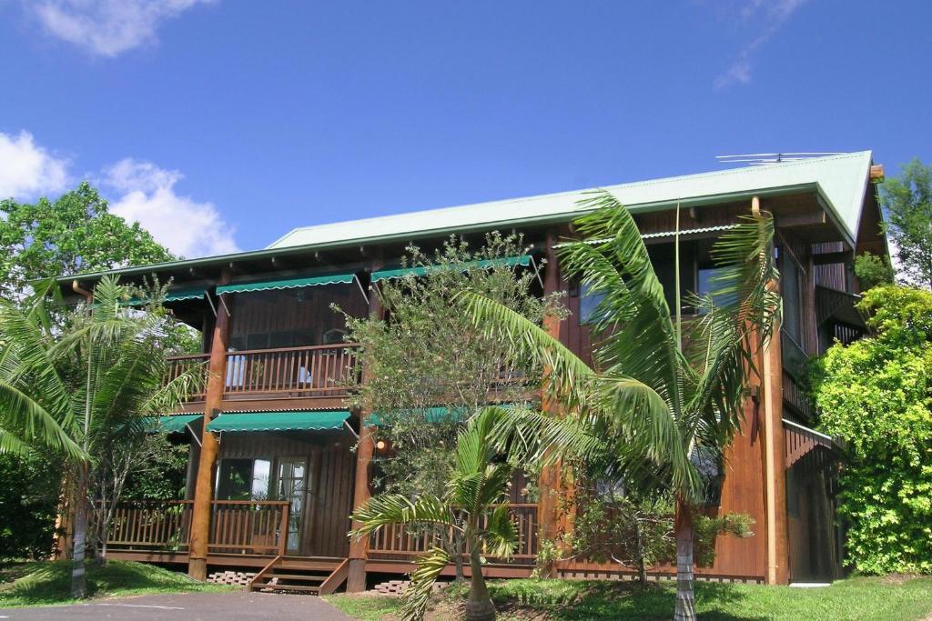 een huis met een veranda en palmbomen rondom bij Atherton Blue Gum B&B in Atherton