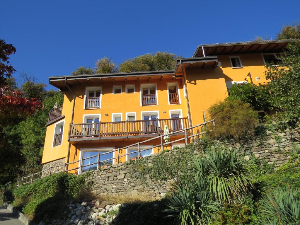 ein gelbes Haus an der Seite eines Hügels in der Unterkunft La Nave B&B in Ponte Cremenaga