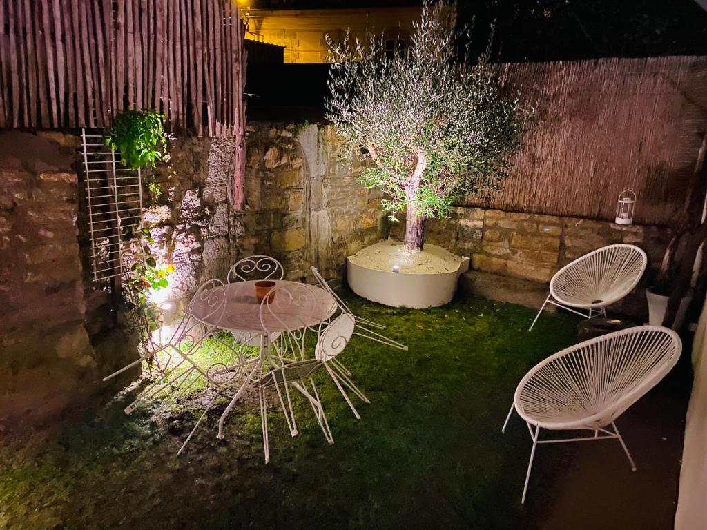 2 Stühle und ein Tisch in einem Garten nachts in der Unterkunft TY LAUMANN petite maison jardin sur le port de vannes avec Parking souterrain in Vannes