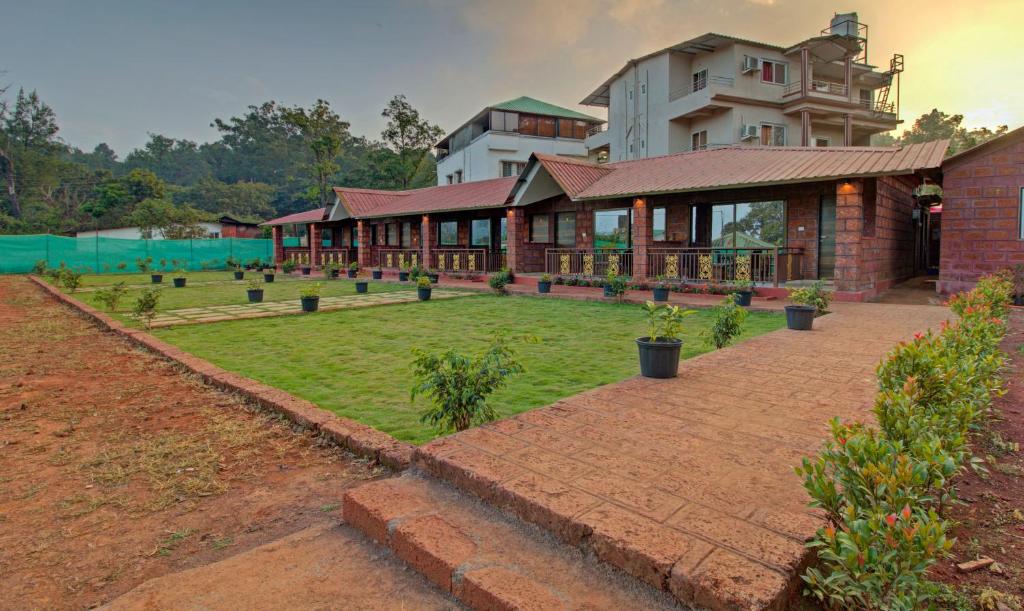 una casa grande con césped delante en Treebo Trend Nakshatra Cottages Mahabaleshwar, en Mahabaleshwar