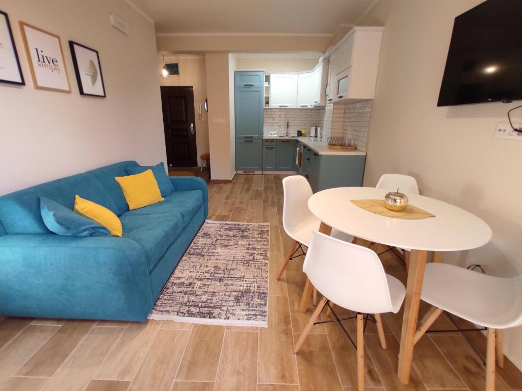a living room with a blue couch and a table at Forest Stream in Herceg-Novi