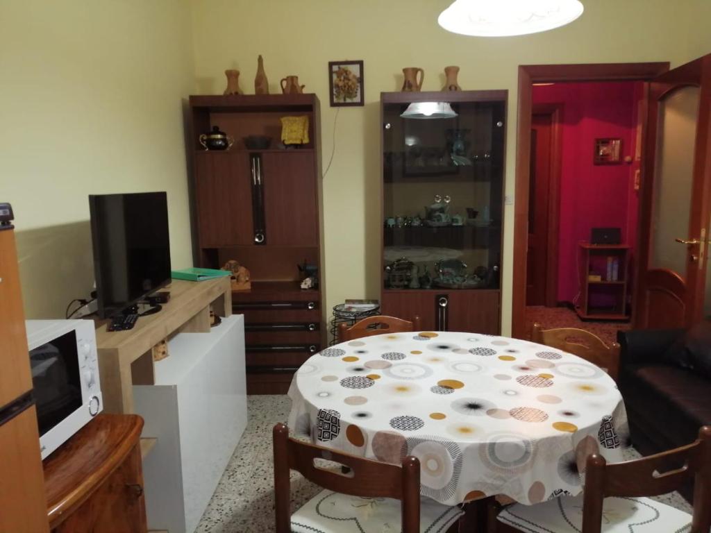 a living room with a table and a kitchen at GRAZIOSO APPARTAMENTO IN ZONA SANTA RITA in Turin