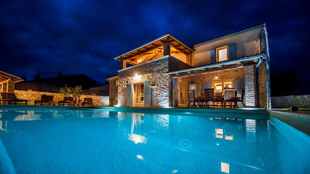 een villa met een zwembad in de nacht bij Villa Tomani in Krmed
