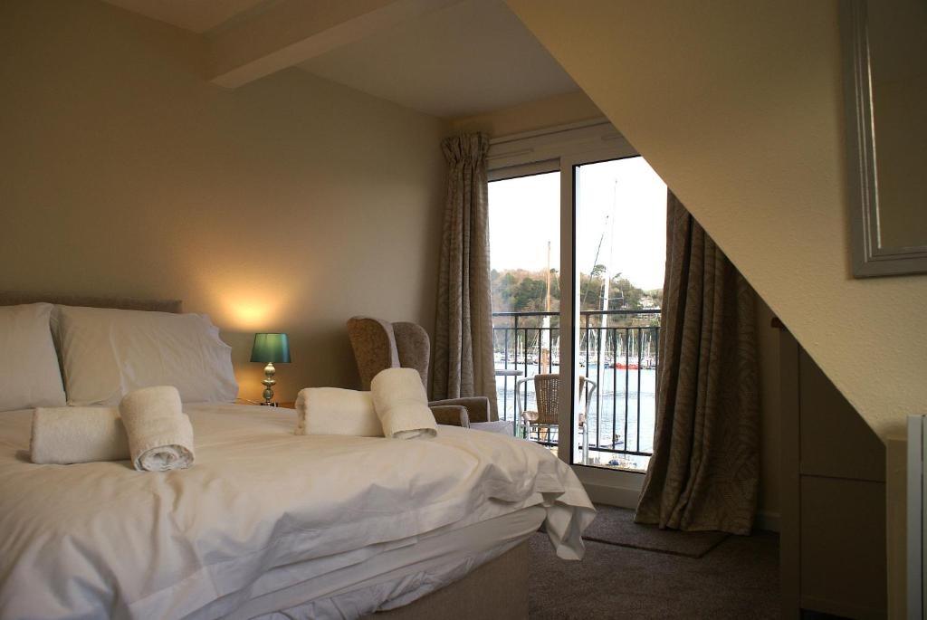 a bedroom with a white bed and a balcony at Riverside 3 in Dartmouth