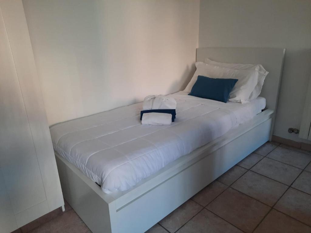 Una cama blanca con almohadas azules y blancas. en STUDIO FERRARIN 3 by ITALYVING, en Rho