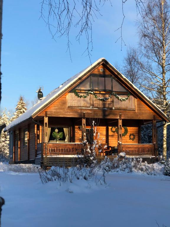 una cabaña de madera en la nieve con nieve en Chalet Holmen, en Uddevalla