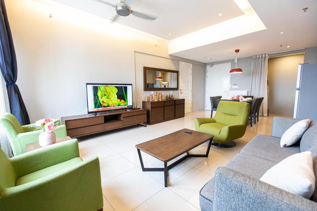 sala de estar con sofá, sillas y TV en Unique Tropicana Seaview Luxury 2BR Suite en George Town