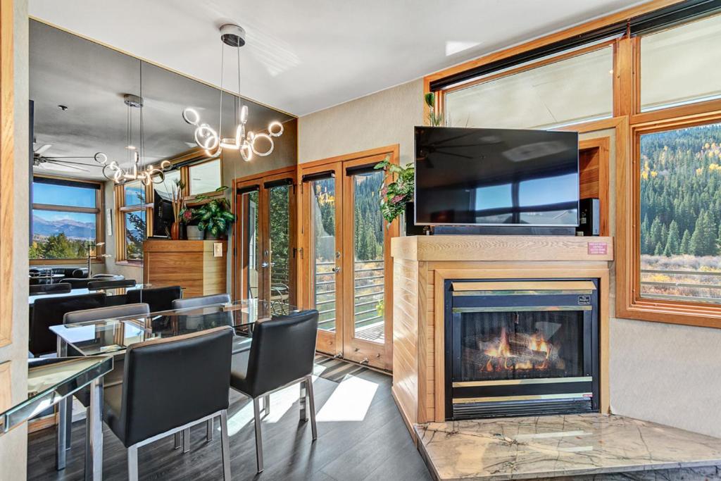 a dining room with a fireplace and a tv at River Bank Lodge 2916 in Keystone