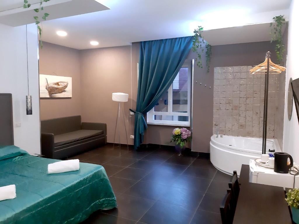 - une chambre avec un lit, une baignoire et un canapé dans l'établissement Pit Stop Napoli Centrale, à Naples