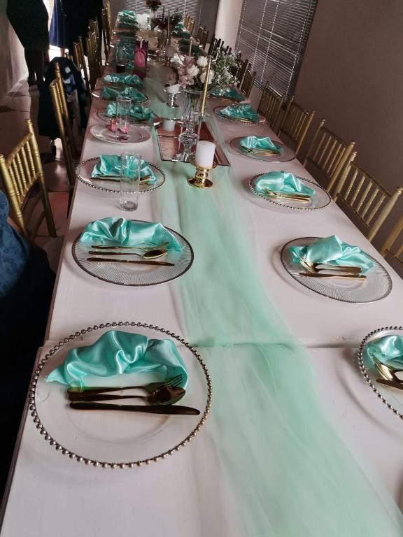 a long table with green plates and napkins on it at 101 Newlands West in Durban