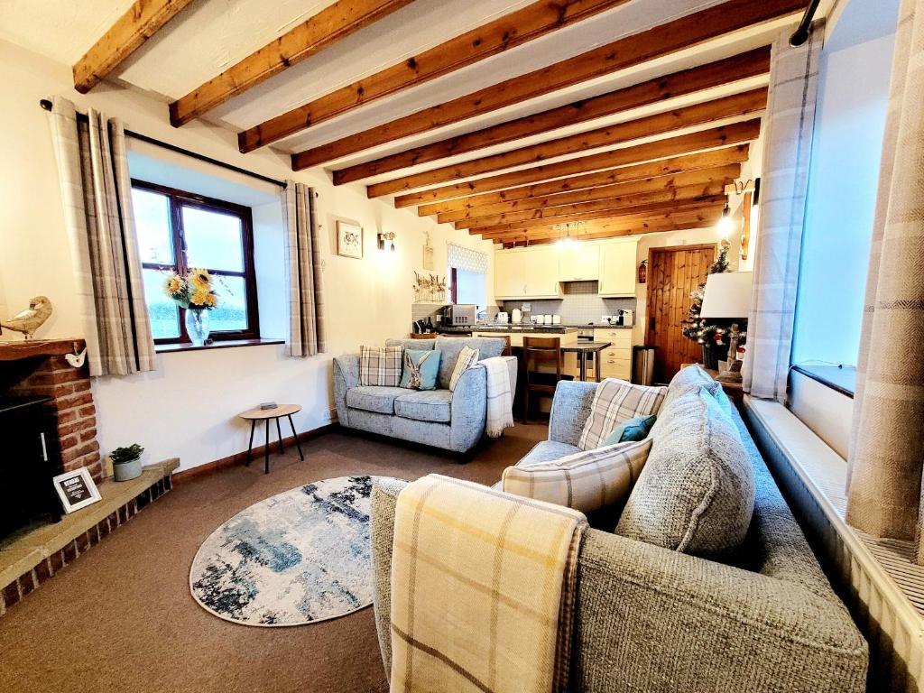 sala de estar con 2 sofás y chimenea en Grosmont Cottage, Ruswarp en Whitby