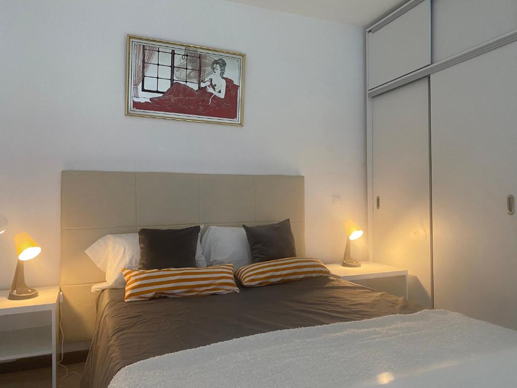 um quarto com uma cama com dois candeeiros e uma imagem na parede em Cesária Évora Loft em Praia