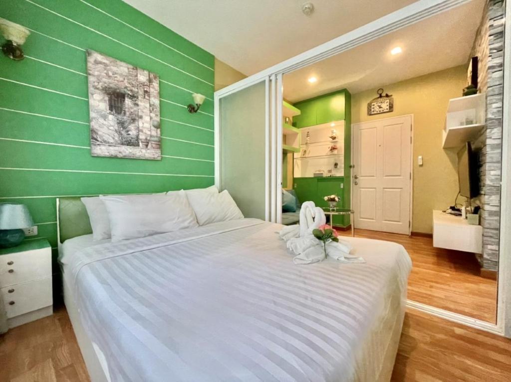 a large bed in a room with green walls at The trust huahin resort condo greeny room in Hua Hin