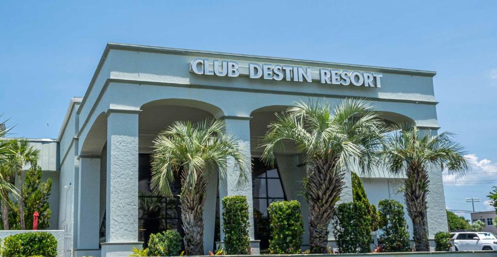 a club destiny resort with palm trees in front of it at Club Destin Condos in Destin
