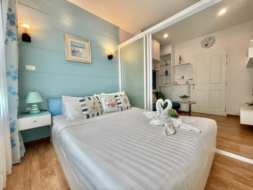 Un dormitorio con una cama blanca con una toalla. en The trust huahin sky room condo pool view, en Hua Hin