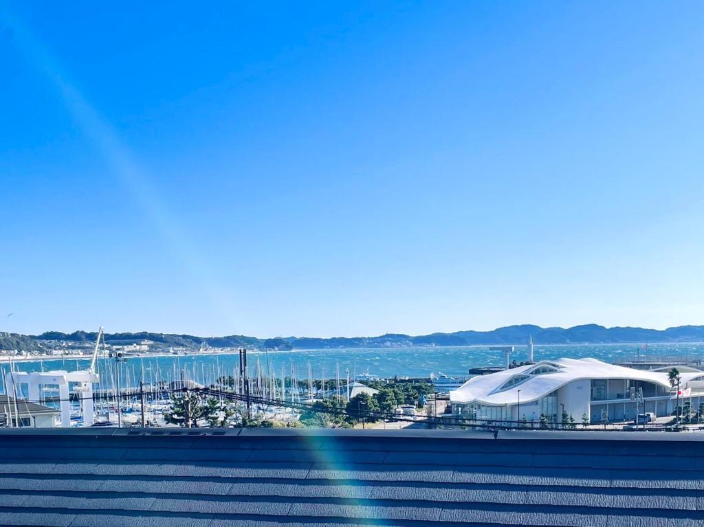 una vista del puerto con un edificio y el océano en オーシャンビュー 加美屋リゾート 江ノ島,江ノ島の島内,仲見世通りから3分,海と日の出を臨む貸切の和モダン別荘 en Fujisawa