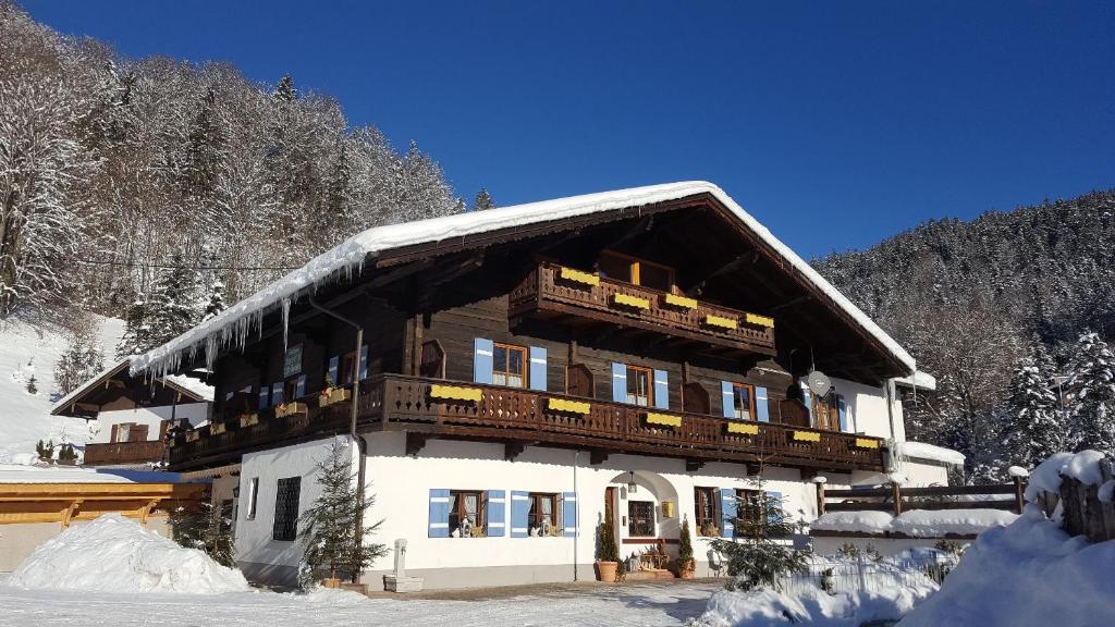 un gran edificio con nieve en el techo en Pension Etzerschlössl, en Berchtesgaden