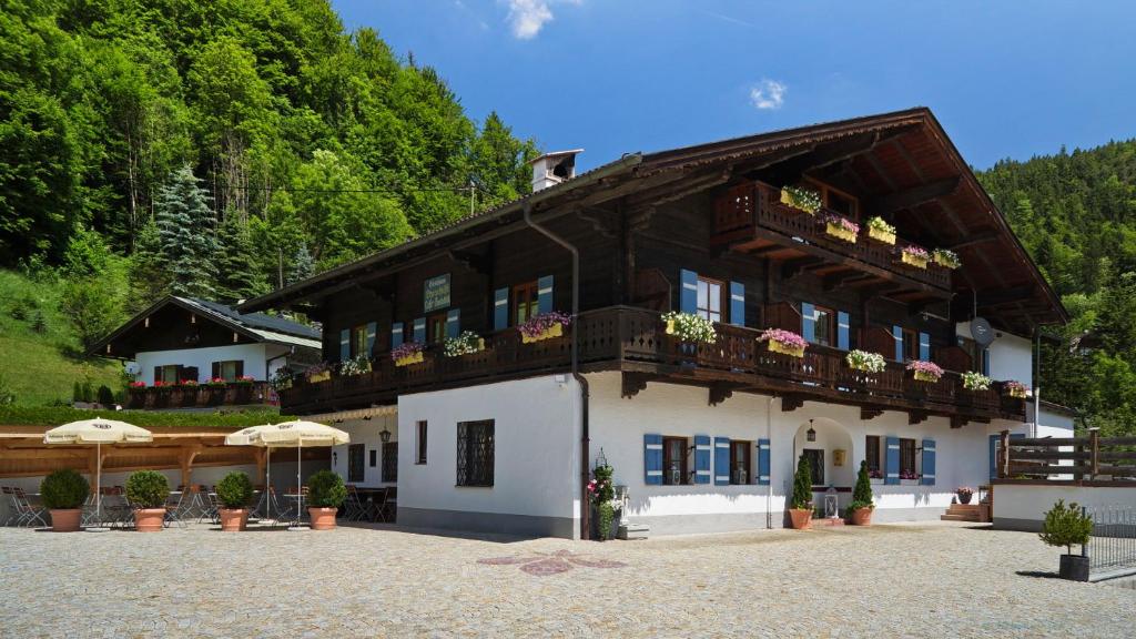 un bâtiment avec des fleurs sur ses balcons dans l'établissement Pension Etzerschlössl, à Berchtesgaden