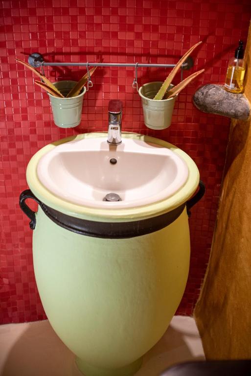 a sink in a bathroom with two buckets on the wall at Villa Orpheus Santorini in Megalokhori