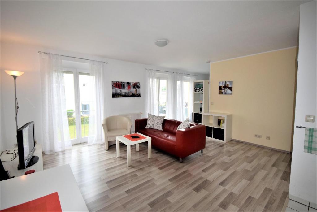 ein Wohnzimmer mit einem roten Sofa und einem Tisch in der Unterkunft Naherholung Ferienwohnung Bad Säckingen in Bad Säckingen