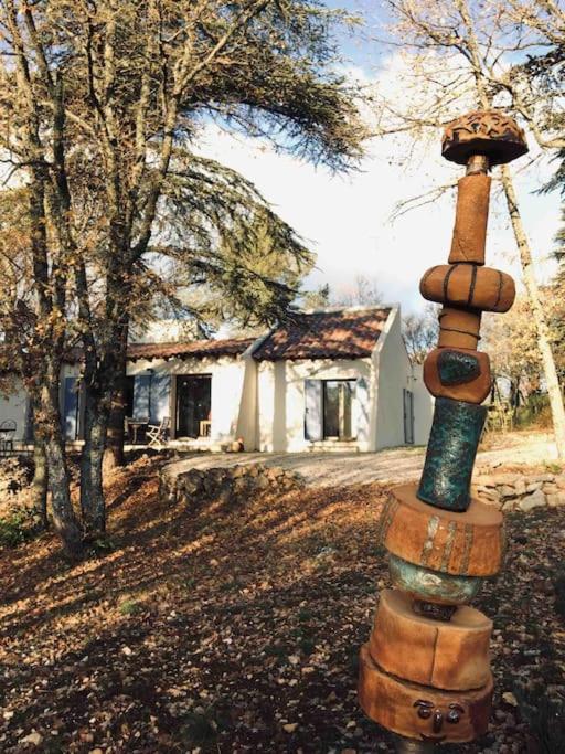 un pôle de totem devant une maison dans l'établissement La maison de Mado et sa cabane dans les arbres, à Plan dʼAups