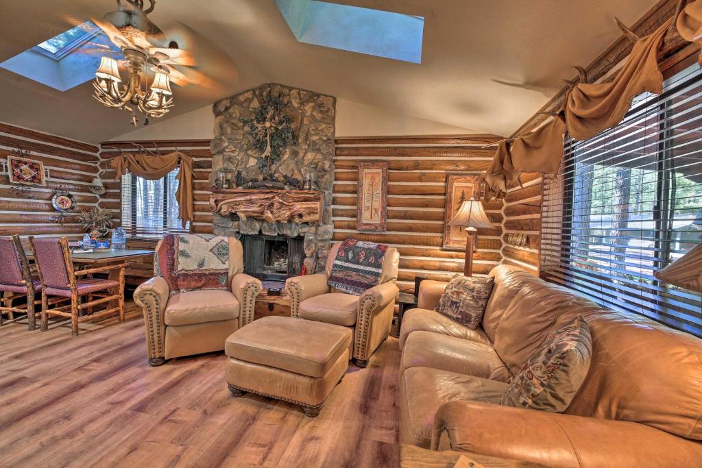 ein Wohnzimmer mit einem Sofa, Stühlen und einem Kamin in der Unterkunft Rustic Lakeside Cabin - Family and Pet Friendly! in Pinetop-Lakeside