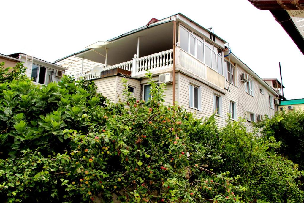 a white house with trees in front of it at Prostor Guest House in Loo